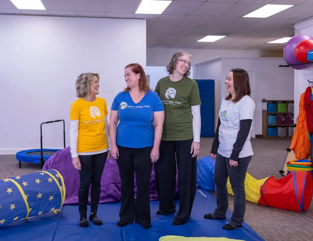 Children and speech-language pathologists laughing together